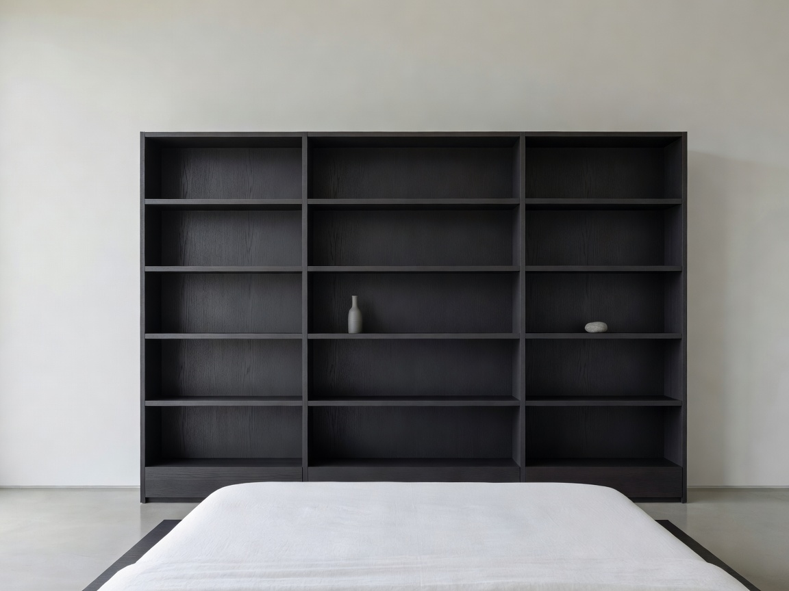 Matte charcoal ash open-pore black wooden shelving in ultra-minimal bedroom